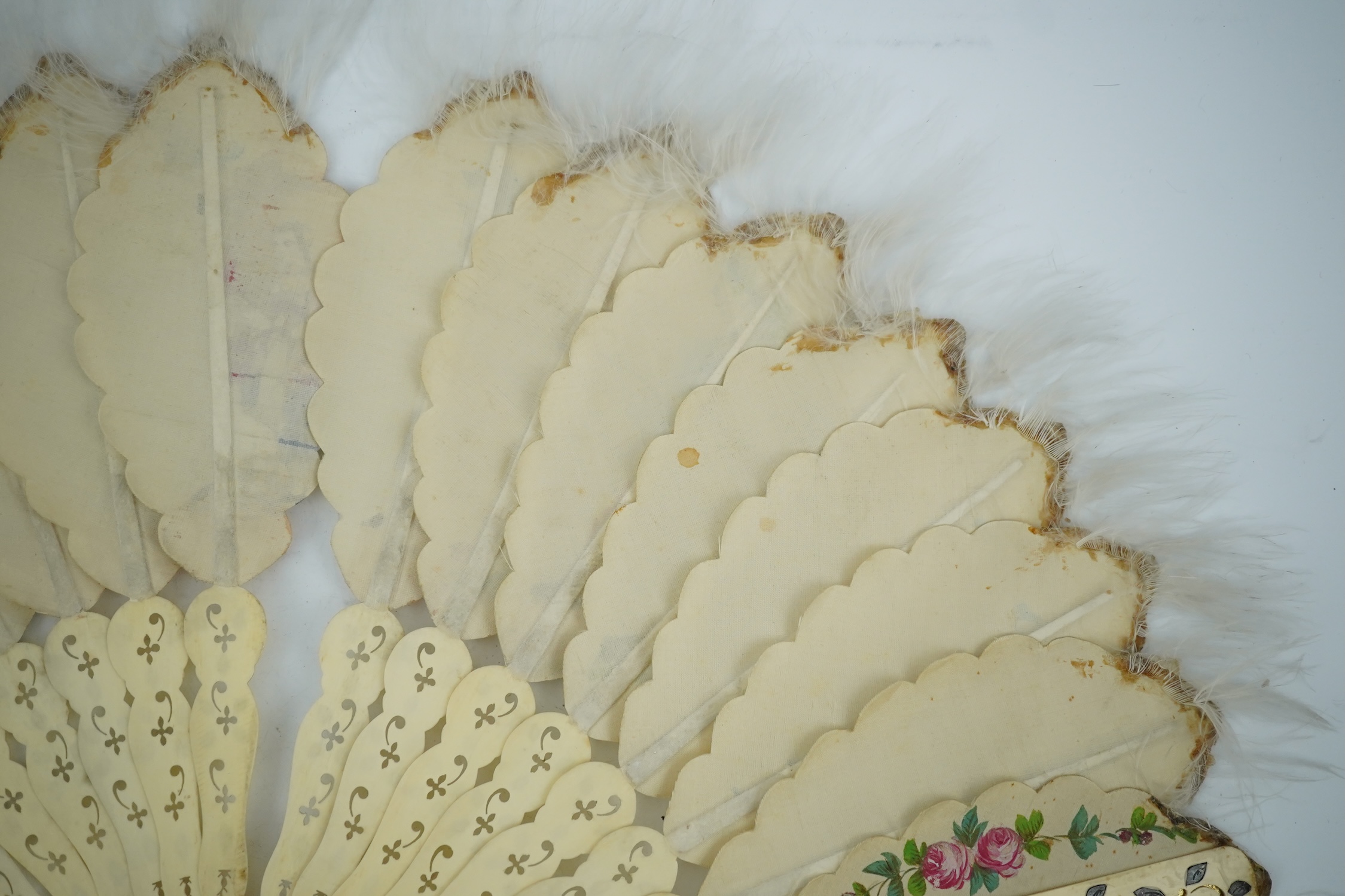 Three French fans: a mother of pearl and sequin fan boxed, a painted silk, feather and bone fan and a gilt decorated bone figural paper fan, the two bone fans having gilt mirrored mounts on the guards, figural paper fan